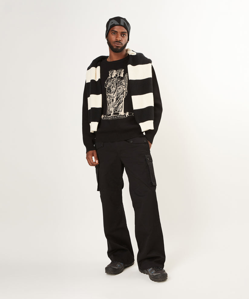 CUSTOM_ALT_TEXT: Male model wearing Paper Planes Birdseye Statue Crewneck Sweater with Planes Logo Beanie.