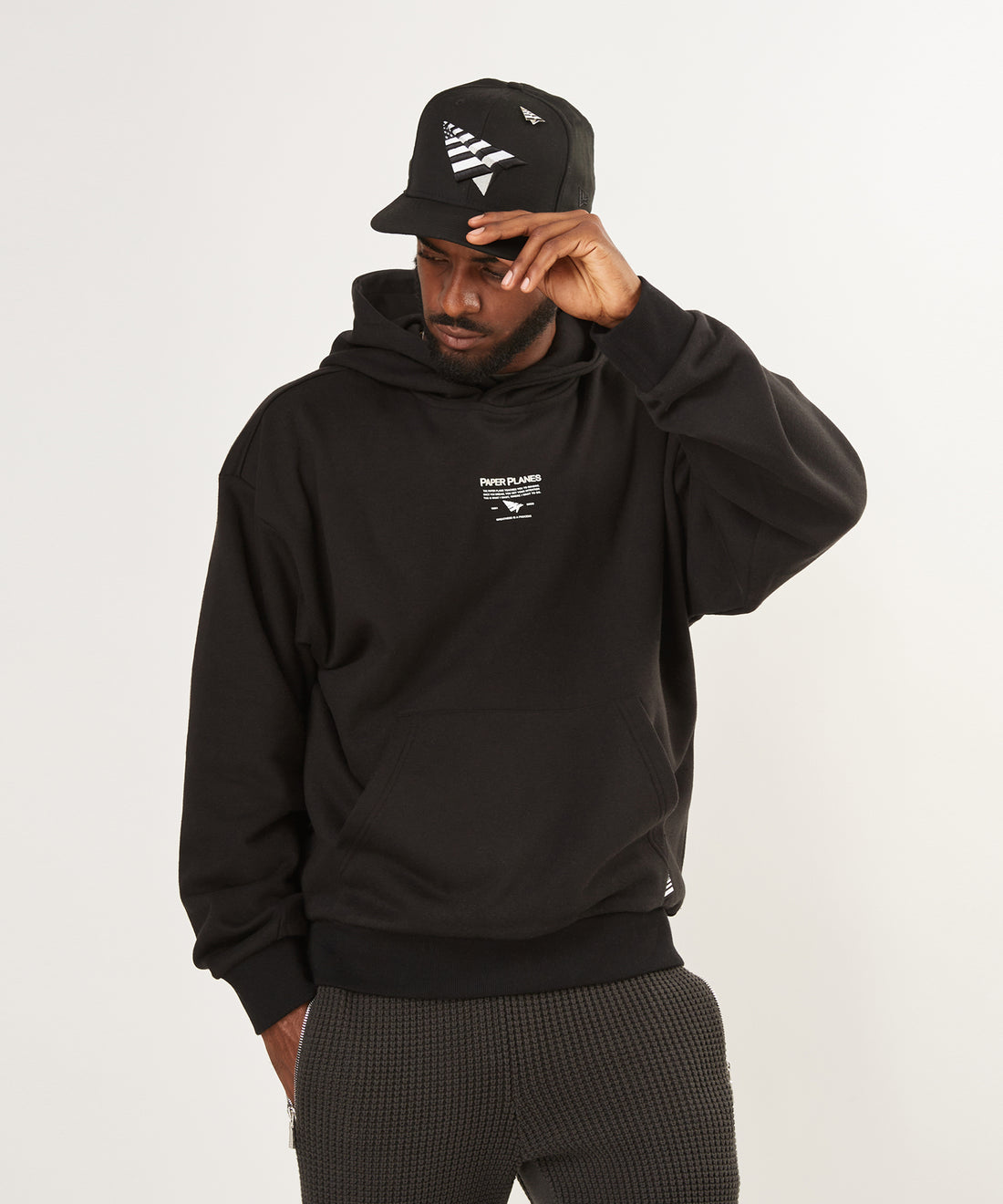 CUSTOM_ALT_TEXT: Male model wearing Paper Planes Mantra Hoodie, color Black.