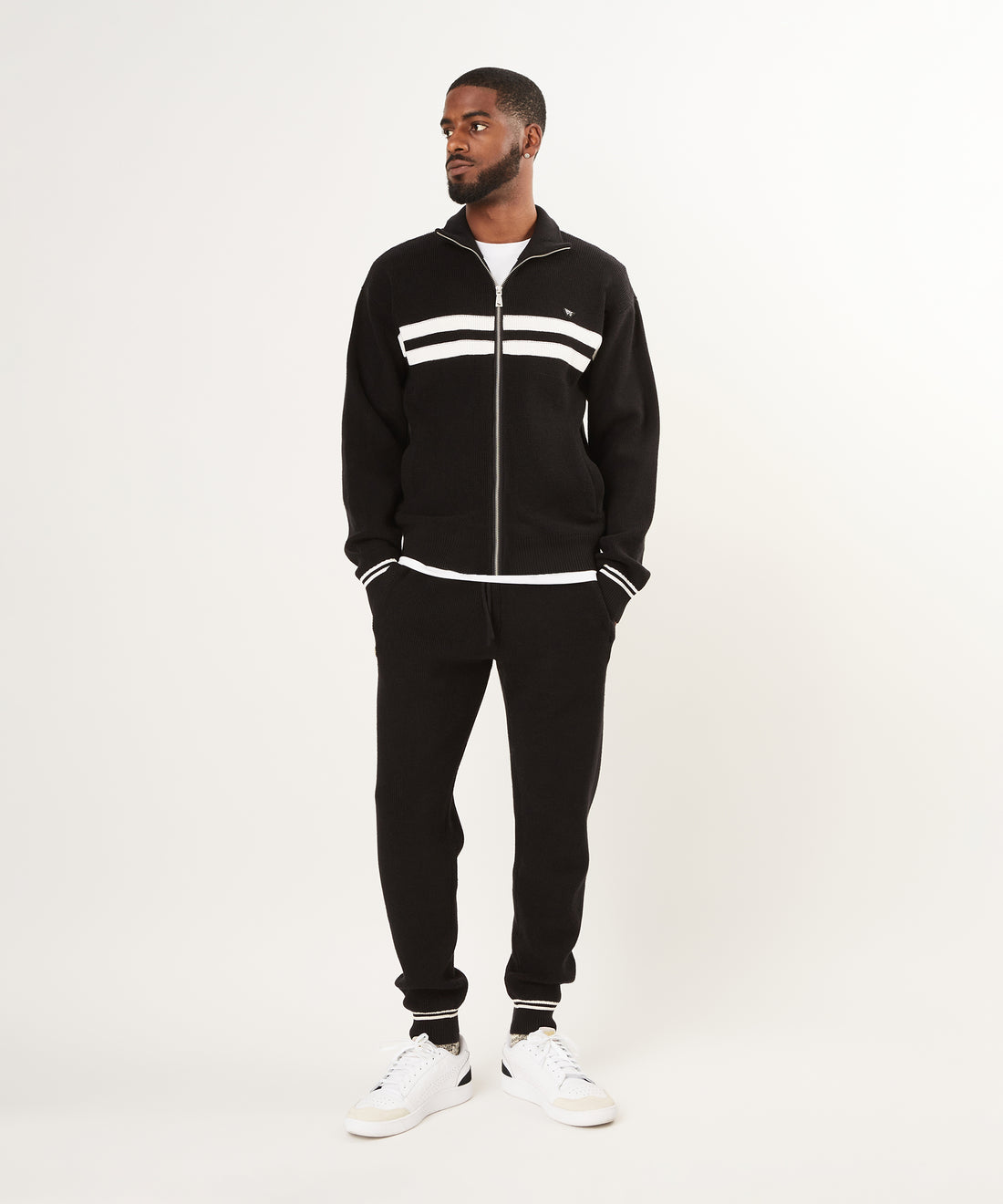 CUSTOM_ALT_TEXT: Male model wearing Paper Planes Sweater Track Jacket and Jogger set, color Black.